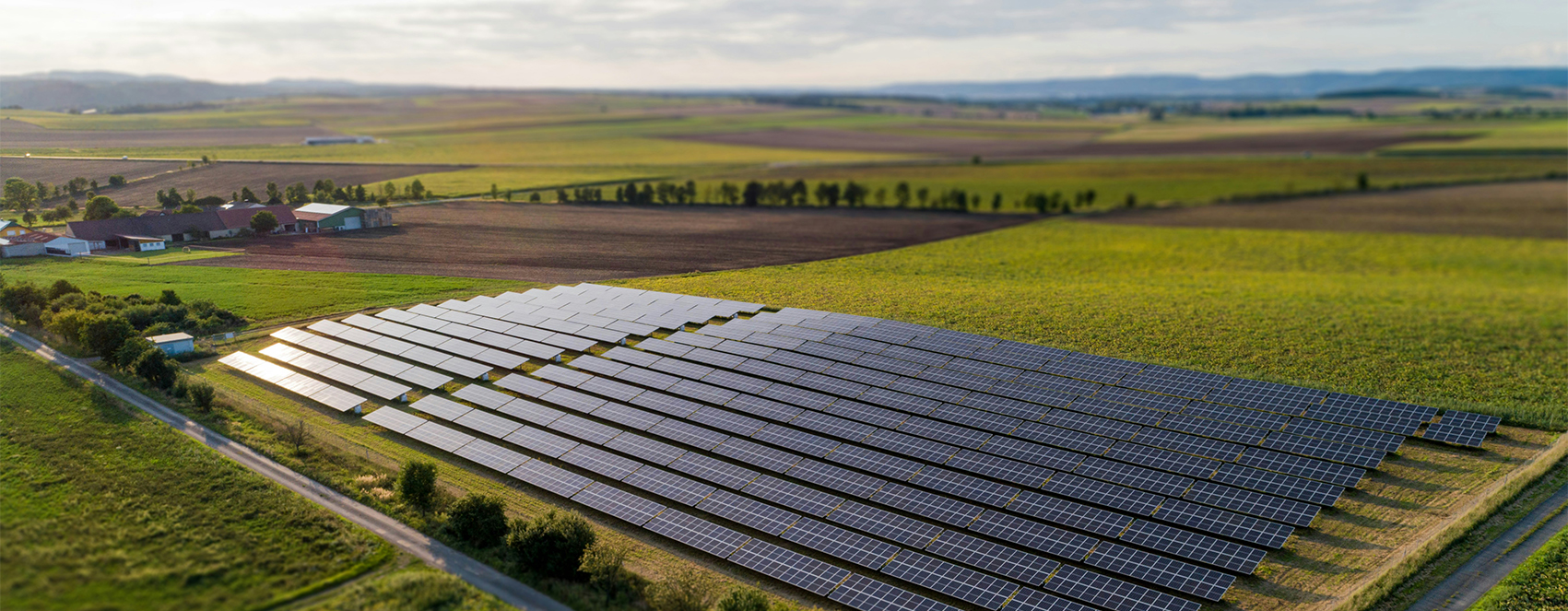 Luftaufnahme eines großen Solarfelds auf freier Fläche in NRW. Die Photovoltaikmodule erzeugen umweltfreundlichen Strom und zeigen die Leistungsfähigkeit moderner Solartechnik.